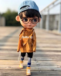 a small doll wearing glasses and a jacket