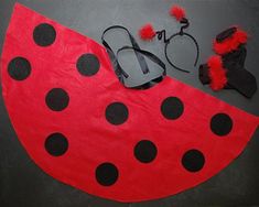 a ladybug costume is laying on the floor next to some shoes and sunglasses