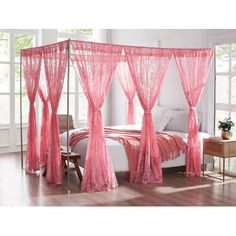 a pink canopy bed with sheer curtains on the top and bottom posts, in a bedroom