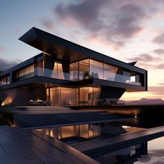 a modern house is lit up at night with the sun going down on it's roof