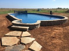 an empty swimming pool surrounded by stone steps