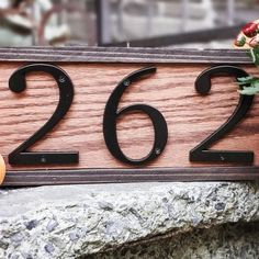 a close up of a house number sign with flowers