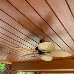 a ceiling fan mounted to the side of a wooden ceiling