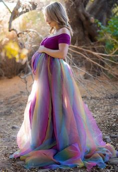 Our Short-Sleeve Off the Shoulder Rainbow Baby Gown is the perfect photoshoot maternity gown! With a cross over sweetheart bust, a slim fit bodice, a simple flare, and a full rainbow bodice overlay this gown has a complete wow factor.  Gowns are designed and made in our mom-run gown shop in Boise, Idaho. 100% USA. All gowns come with free basic alterations to include length and general size adjustments. Shortly after placing your order, you'll receive an automated email requesting basic measurem Rainbow Gown, Maternity Shoot Dresses, Maternity Dresses Photography, Maternity Evening Dress, Casual Maternity, Tassel Dress, Maternity Gowns, Gauze Dress, Pregnant Woman