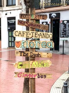 a wooden sign post with many different signs on it