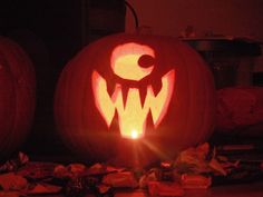 two carved pumpkins sitting on top of a table with candy in front of them