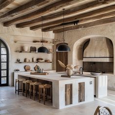 a large kitchen with an island counter top and wooden beams on the ceiling above it