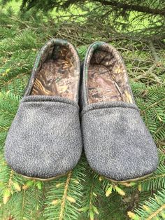 a pair of gray slippers sitting on top of a tree