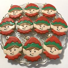 there are many decorated cookies in the shape of elf's heads on a plate