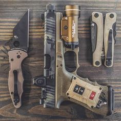 several different types of knifes and knives laid out on a wooden table with one being used as a flashlight