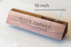 a wooden business card holder with the name peter parker written in black ink on it