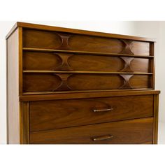 a wooden dresser with three drawers on it