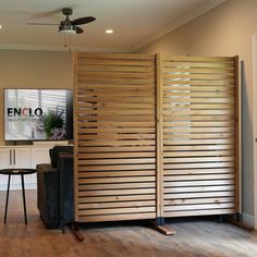 a room divider made out of wooden slats in front of a flat screen tv