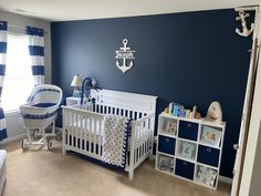 a baby's room is decorated in blue and white with an anchor on the wall