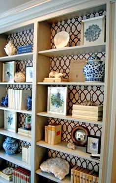 the shelves are decorated with blue and white vases, books, and other decorative items