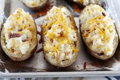 baked potatoes with cheese and bacon are on a baking sheet, ready to be eaten