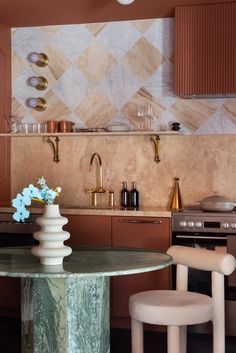 a kitchen with marble counter tops and gold accents on the backsplash is pictured in this image