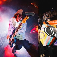 a man holding a guitar on top of a stage next to another person with an umbrella