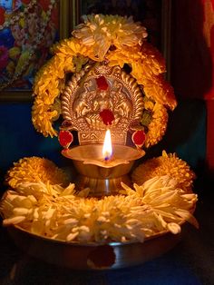 a lit candle is surrounded by yellow flowers