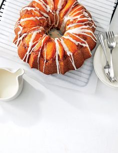 a bundt cake sitting on top of a cooling rack next to a cup and saucer