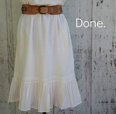 a white dress with the words donee on it and a brown belt around the waist