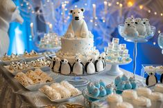 a table topped with cakes and cupcakes covered in white frosted icing