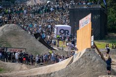 a man riding a skateboard up the side of a ramp in front of a crowd