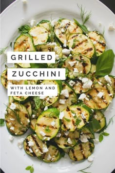 grilled zucchini with lemon and feta cheese on a white platter