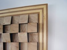 a wooden frame with squares cut out of it on the wall next to a white wall