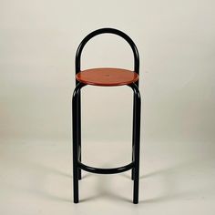 a black and brown stool with an orange seat