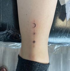 a small star and moon tattoo on the left side of the leg is shown in black ink