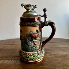 a coffee pot sitting on top of a wooden table next to a bird figurine