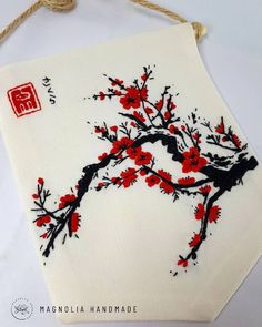 an embroidered piece of cloth with red flowers on it