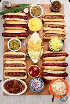 hot dogs and condiments are laid out on a cutting board to be served