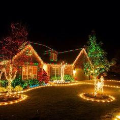 christmas lights decorate the front yard of a house in this suburban neighborhood, which has been decorated with trees and wreaths