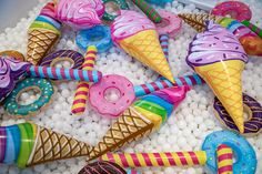 colorful ice cream and doughnuts are in a bowl filled with candies, pretzels, and candy