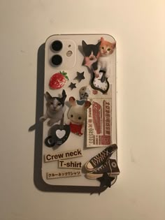 an iphone case with various stickers on it and a cat in the back ground