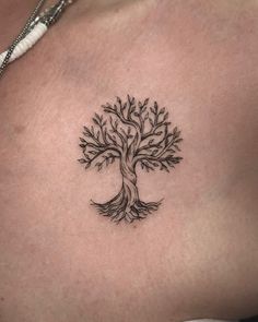 a woman's chest with a tree tattoo on it