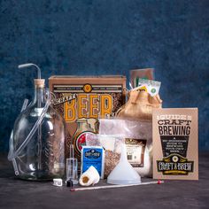 an assortment of crafting supplies sitting on a table next to a bottle and bag