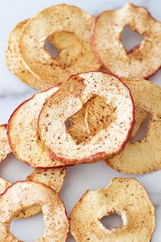 baked cinnamon apple slices on a white marble counter top with the words, dehydrated cinnamon apples