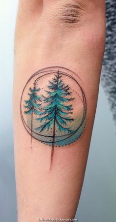 a small tattoo on the arm of a man with pine trees in a snow globe