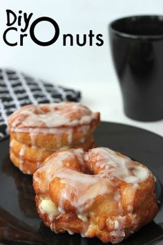 two glazed donuts sitting on top of a black plate