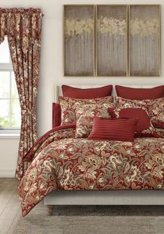 a bed in a bedroom with red and gold comforter set on top of it