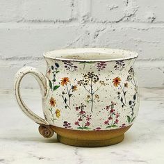 a white coffee cup with flowers painted on it