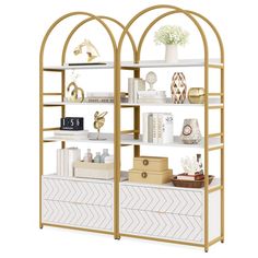 a white and gold book shelf with shelves