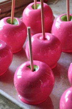 there are many pink apples with toothpicks in them