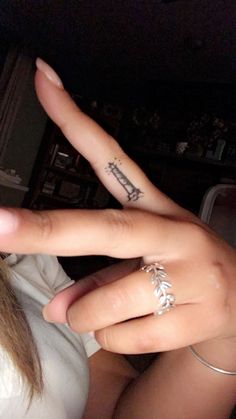 two people with tattoos on their fingers making the v sign