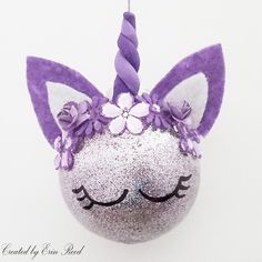 an ornament shaped like a unicorn's head with purple flowers on it