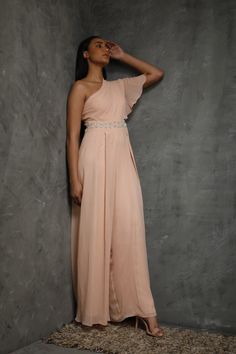 Peach One Shoulder Draped Jumpsuit. Editor's Note This set features a peach one-shoulder draped jumpsuit made off with hand-embroidered with dabka, sequins, pearls, and beads. Color: Peach Fabric: Pure Georgette; Satin Care: Dry Clean Only About the Designer Seema Thukral collection offers glamorous, elegant, and chic clothing for women. It consists of drapes with intricate handwork and embroideries. Festive Maxi Length Jumpsuit For Party, Festive Maxi Length Jumpsuits And Rompers For Party, One Shoulder Embellished Party Dress, One-shoulder Embellished Party Dress, Seema Thukral, Draped Jumpsuit, Hairstylist Quotes, Peach Fabric, Dress Book