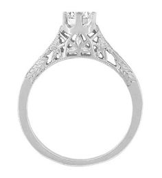 a white gold engagement ring with an intricate filigreet design on the side